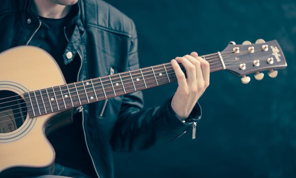Person Holding Brown and Black Guitar